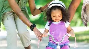 Child riding bike with parent